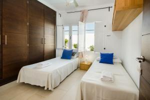 two beds in a room with blue pillows at Las Perseidas in Costa Teguise +22 photos