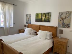 a bedroom with two beds with white sheets at Villa Karon in Almancil +31 photos