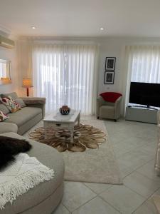 a living room with a couch and a table at Villa Karon in Almancil
