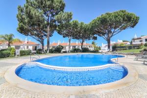 a swimming pool with trees and houses in the background at Villa Karon in Almancil