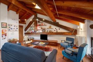 a living room with blue chairs and a tv at La Mansarda del Viaggiatore in Pont-Saint-Martin