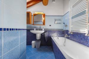 a blue tiled bathroom with a tub and a sink at La Mansarda del Viaggiatore in Pont-Saint-Martin +32 photos