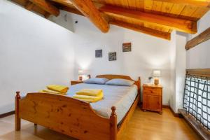 a bedroom with a wooden bed with yellow towels on it at La Mansarda del Viaggiatore in Pont-Saint-Martin