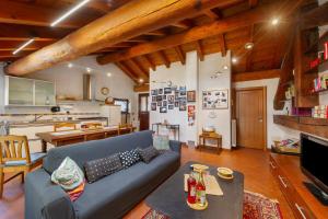 a living room with a blue couch and a kitchen at La Mansarda del Viaggiatore in Pont-Saint-Martin