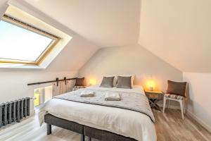 a bedroom with a large bed in a attic at Villa Léonie - piscine intérieure in Kerlouan +25 photos