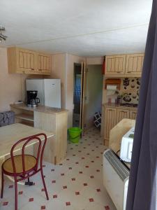 a small kitchen with a table and chairs in a room at Camping Sainte-Jalle in Sainte-Jalle
