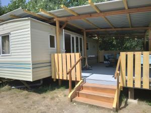 a tiny house with a deck and a pergola at Camping Sainte-Jalle in Sainte-Jalle +2 photos