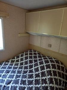 a small bedroom with a bed and a window at Camping Sainte-Jalle in Sainte-Jalle