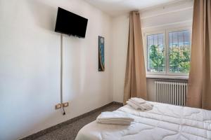 a bedroom with a bed and a tv on the wall at Lases Piano Terra in Albiano
