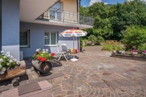 a patio with an umbrella next to a house at Lases Piano Terra in Albiano