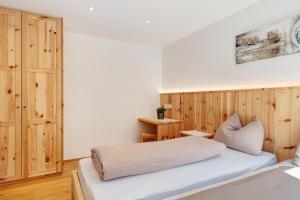 a bedroom with two beds and a wooden wall at Ferienhaus Tholer Hof in San Genesio Atesino