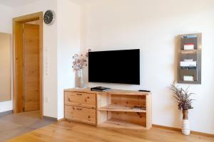 a flat screen tv sitting on top of a wooden cabinet at Ferienhaus Tholer Hof in San Genesio Atesino