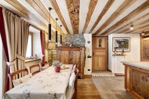 a dining room with a table and a kitchen at Il Cuore della Valdigne in Morgex