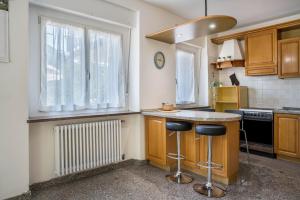 a kitchen with a counter and two stools in it at Lases Piano Terra in Albiano
