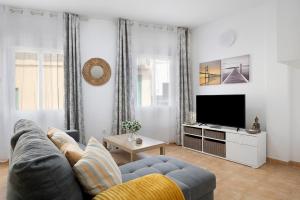 a living room with a couch and a tv at Campo Amor Bajo in Arrecife