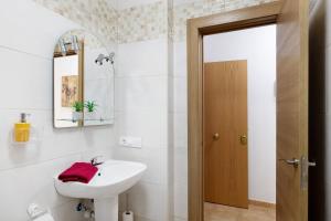 a white bathroom with a sink and a mirror at Campo Amor Bajo in Arrecife +20 photos