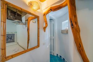 a mirror on the wall in a bathroom at Casa Monorosa in Porto Rotondo +24 photos