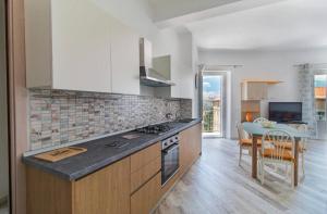 a kitchen with a counter top and a table in a room at Appartamento Castula in Dorgali +9 photos