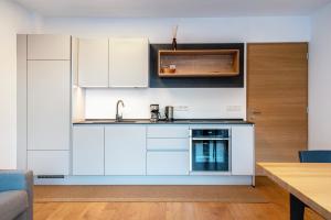 a kitchen with white cabinets and a sink at Ferienwohnungen Karin - Cabernet in Termeno