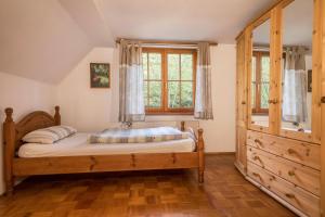 a bedroom with a wooden bed and a window at Ferienwohnung Achraintal 1 in Lindau
