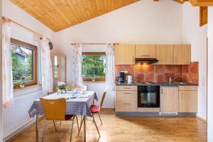 a kitchen with a table and chairs and a kitchen with a stove at Ferienhaus Katrin in Bad Urach