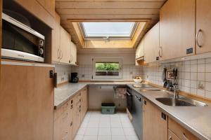 a kitchen with wooden cabinets and a skylight at Fewo Naturliebe - keine Monteure in Dornhan