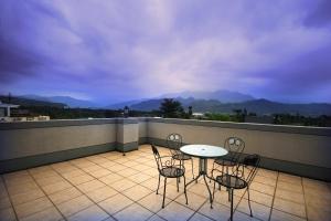 a patio with a table and chairs on a balcony at Pingguo De Jia Du Jia Homestay in Jiji