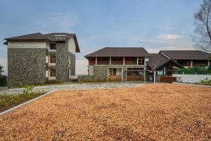 a house with a gravel driveway in front of it at Olive Woods in Chinnakanal