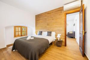 a bedroom with a large bed with a wooden wall at Sa Caseta Biniali in Biniali +22 photos
