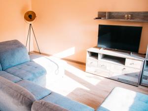 a living room with a couch and a flat screen tv at Ferienhaus Paula in Olsberg