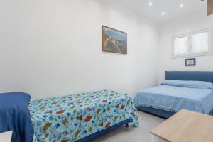 a bedroom with a bed and a bed and a table at Villa Mare Blu in Palermo