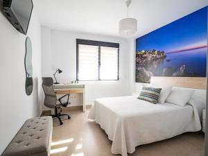 a bedroom with a bed and a desk and a chair at 'Mi Esperanza' in Almuñécar