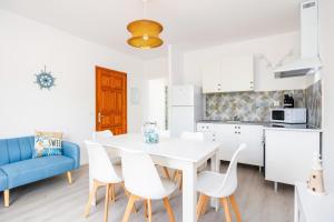 a kitchen and dining room with a white table and chairs at Gran Sol Family 6 in Felanitx