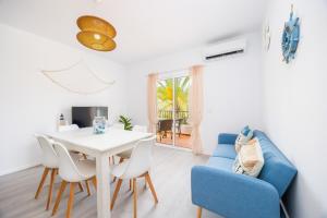 a dining room with a white table and blue chairs at Gran Sol Family 6 in Felanitx