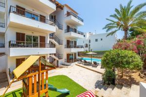 an apartment with a playground in front of a building at Gran Sol Family 6 in Felanitx