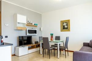 a living room with a table and chairs and a kitchen at Belvedere in Scarlino