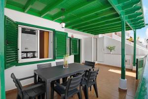 a dining room with a black table and chairs at Casa Playa Palmeras in Puerto del Carmen