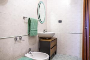 a white bathroom with a sink and a mirror at Belvedere in Scarlino