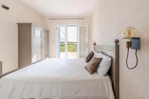 a bedroom with a large white bed with a window at Casale 50 Elegante Villa a Otranto in Otranto +36 photos