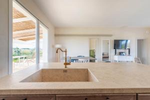 a kitchen with a sink and a living room at Casale 50 Elegante Villa a Otranto in Otranto