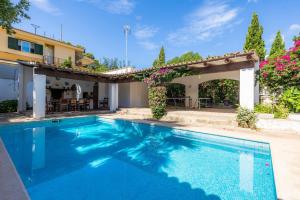 a swimming pool in front of a house at Villa Beach Palmitos in Can Picafort
