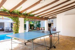 a ping pong table in a room with a pool at Villa Beach Palmitos in Can Picafort