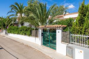 a white fence with a gate on a street at Villa Beach Palmitos in Can Picafort