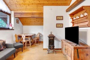a living room with a tv and a table at Casa Serena in Cavalese