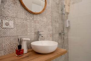a bathroom with a white bowl sink on a wooden counter at Dimora Giulia in Castellana Grotte