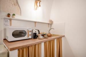 a kitchen counter with a microwave on top of it at Dimora Giulia in Castellana Grotte +24 photos