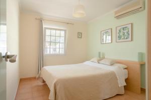 a white bedroom with a bed and a window at Finca Colica in Cómpeta +35 photos