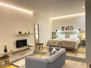 a bedroom with a bed and a couch and a tv at Ladomar Avenida in Horta