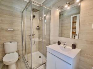 a bathroom with a shower and a toilet and a sink at Ladomar Avenida in Horta +20 photos