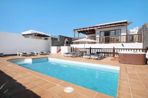 a swimming pool in front of a house at Villa Jeamir I in Playa Blanca